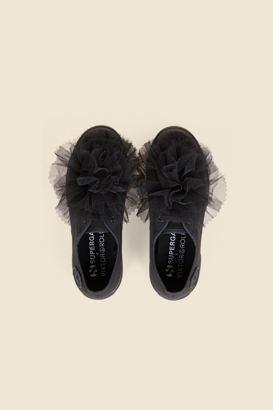 Black canvas sneakers adorned with layered tulle ruffles, offering a bold and stylish statement in modern footwear design.