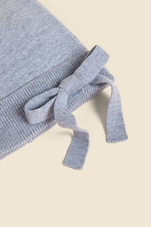 Soft gray knit pillow with an elegant bow detail, showcasing fine craftsmanship and cozy texture, perfect for home decor.