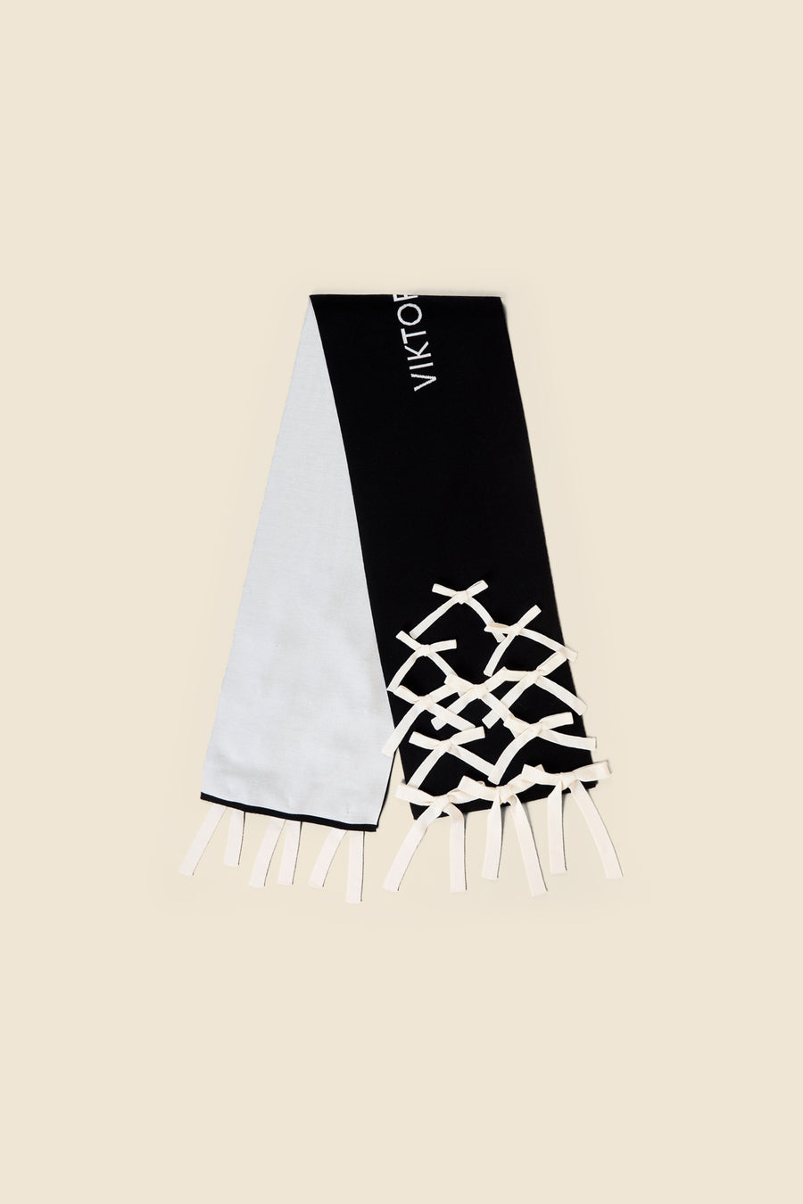 Black and white scarf with crisscross bow design and bold logo, featuring a modern, minimalist style on soft fabric.