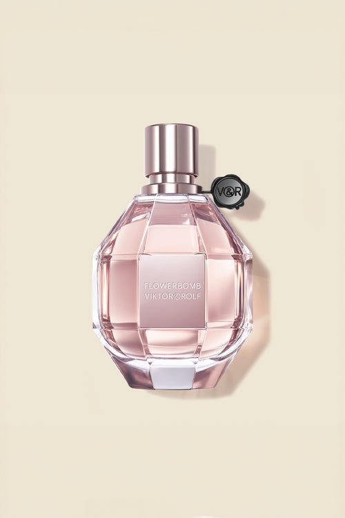 A feminine, diamond-cut glass bottle of Flowerbomb by Viktor & Rolf, featuring a blush pink fragrance for women with floral notes.