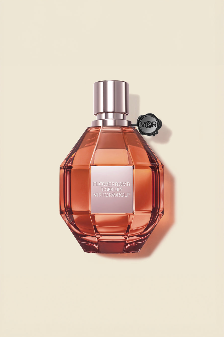 A faceted bottle of Flowerbomb Tiger Lily Eau de Parfum by Viktor & Rolf, in amber tones, exuding a floral aroma for women.