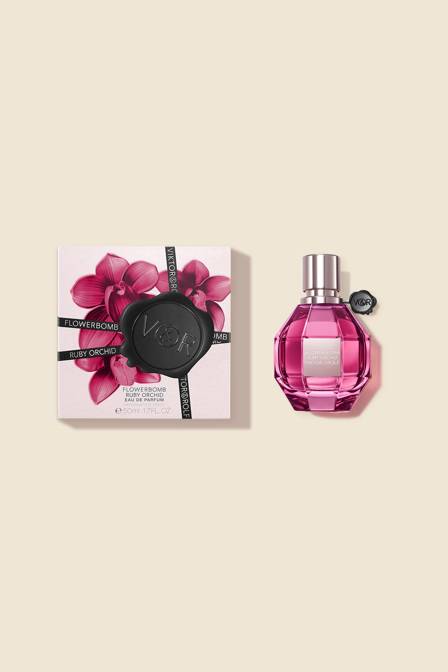 A faceted pink bottle of Flowerbomb Ruby Orchid Eau de Parfum for women, alongside a floral design box by Viktor & Rolf.