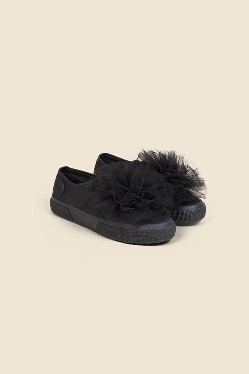 Elegant black sneakers adorned with large tulle rosettes, offering a chic and fashionable touch to casual footwear.