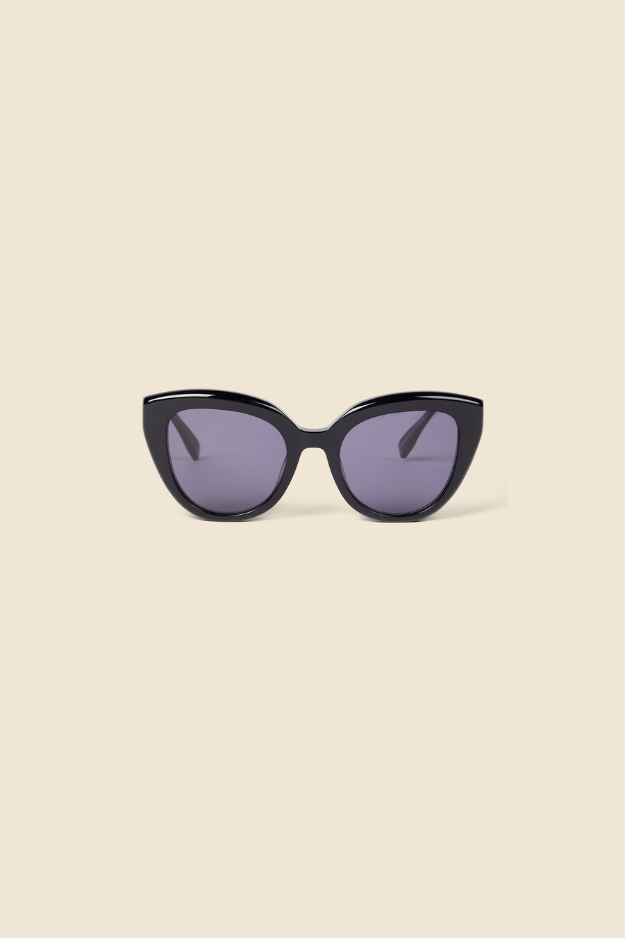 Elegant cat-eye sunglasses with glossy black frames and dark tinted lenses, set against a soft beige background.