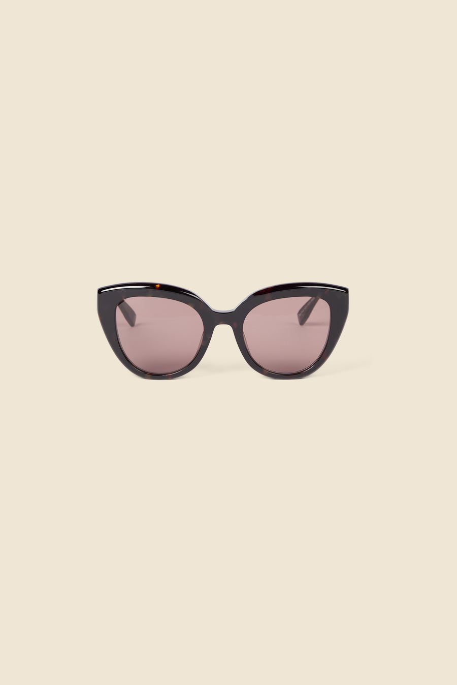 Fashionable cat-eye sunglasses with sleek black tortoiseshell frames and tinted brown lenses, set against a light beige background.