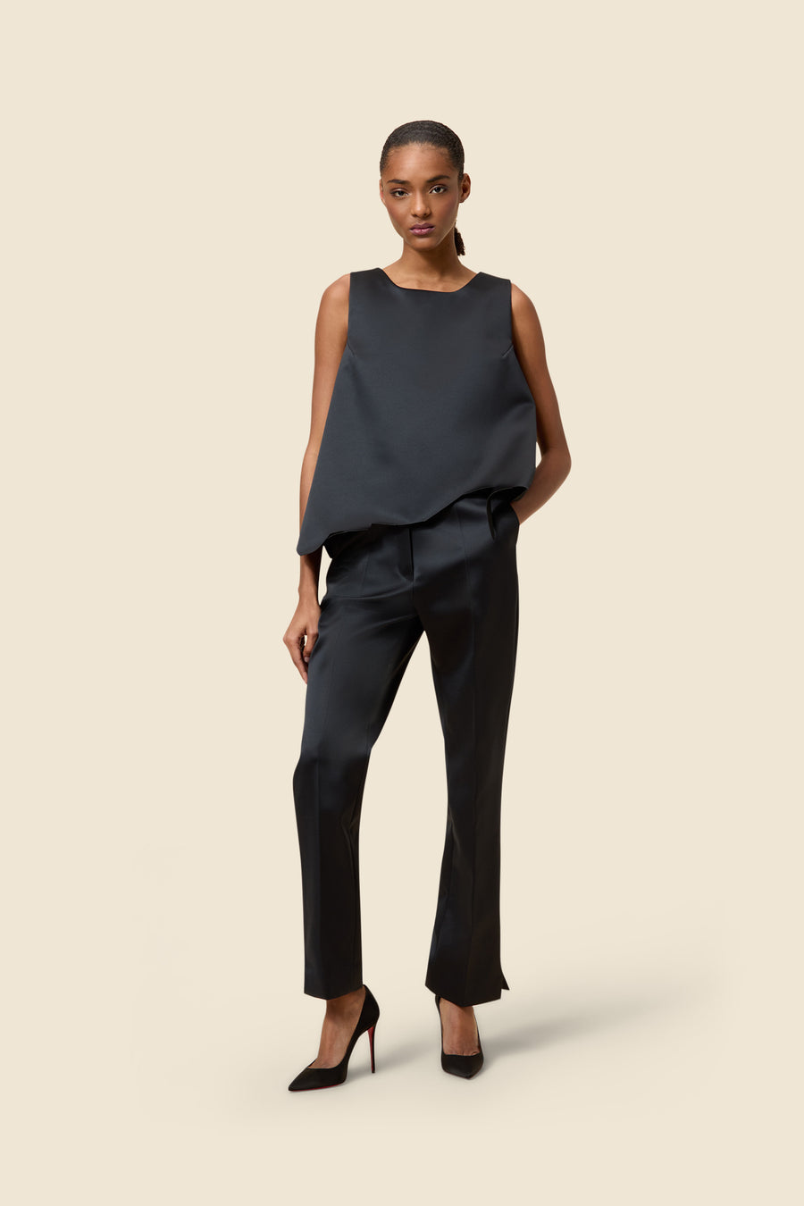 Sleek black satin ensemble featuring a sleeveless top and tailored pants, paired with classic black stiletto heels.