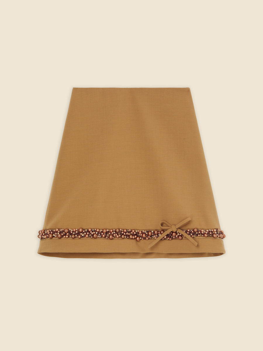 Mustard-colored table runner with intricate beaded border and a side bow, offering a touch of elegance to any table decor.