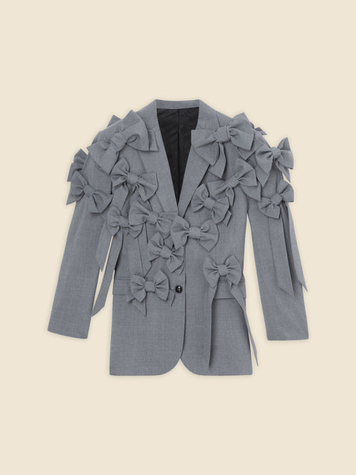 Gray blazer adorned with multiple decorative bows, offering a unique and stylish twist on classic formal attire.