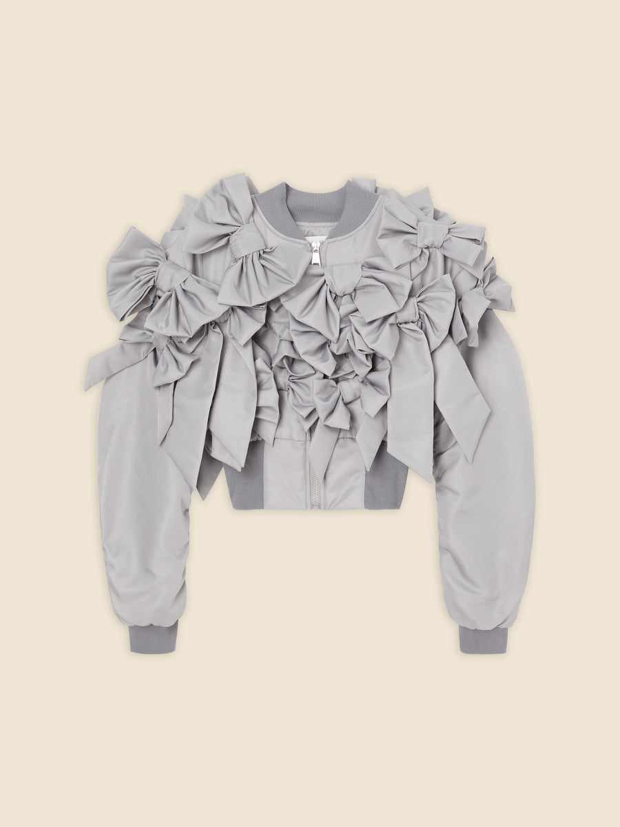 Gray satin bomber jacket adorned with oversized fabric bows creating a textured, dimensional look on a neutral background.