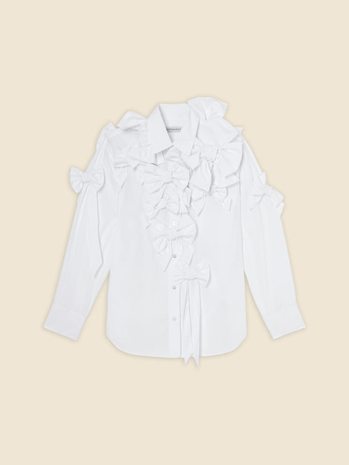 White cotton shirt with multiple decorative bows on the front and shoulders, featuring long sleeves and button-up design.