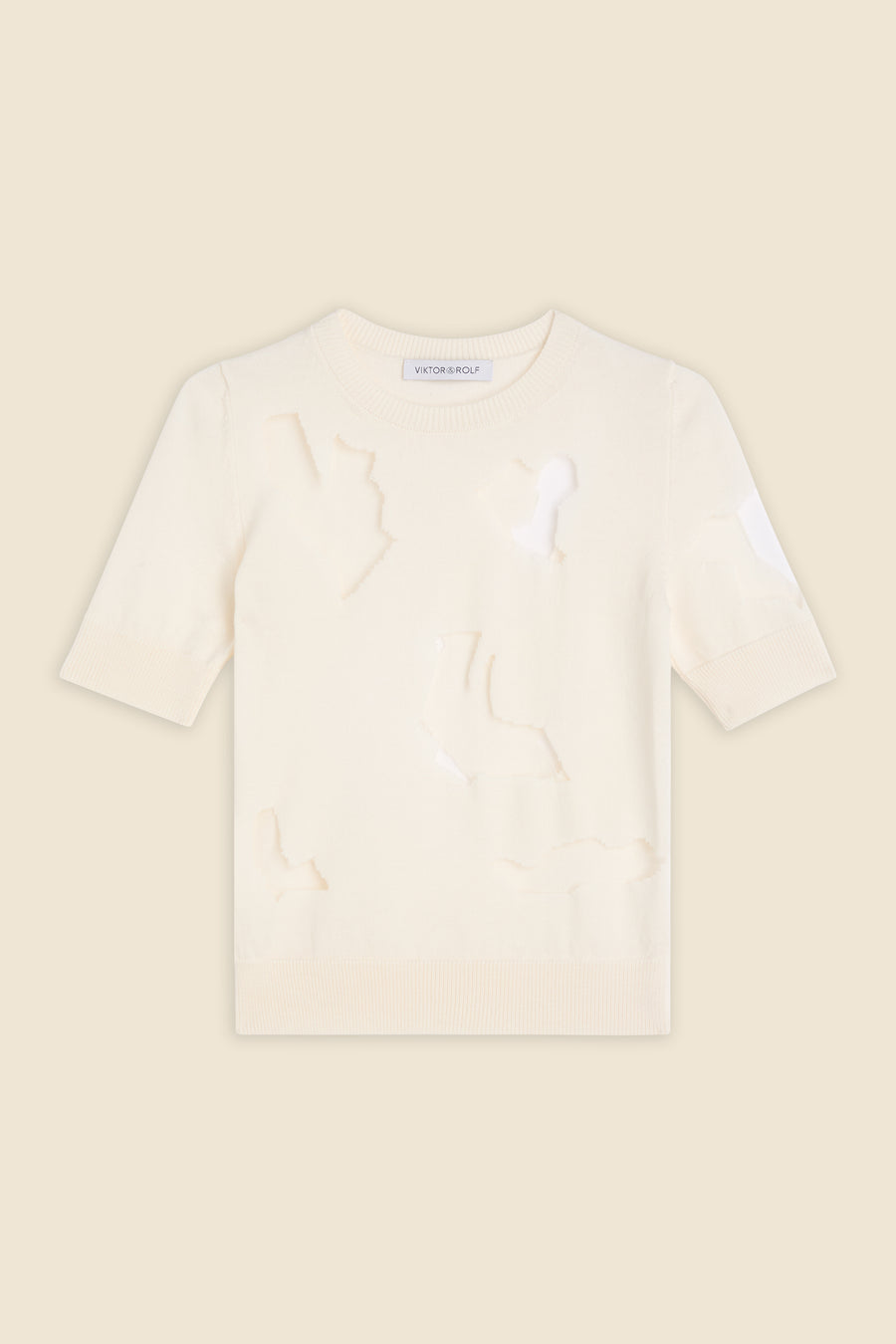 Cream-colored short sleeve sweater with distressed cutout design, ribbed crew neckline, and soft lightweight fabric.